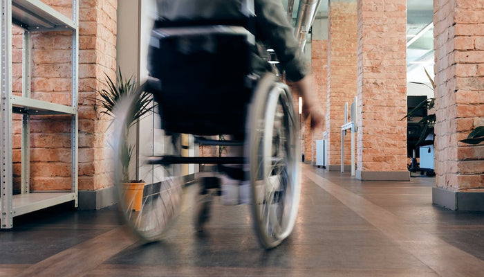 A wheelchair user moving through an office setting
