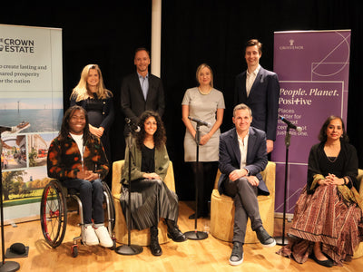 8 panellists smiling together on stage at Inclusive Spaces and Places event launch