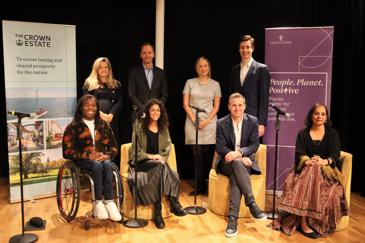 8 panellists smiling together on stage at Inclusive Spaces and Places event launch