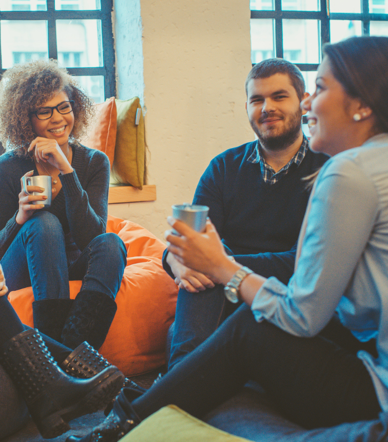 diverse colleagues in soft breakout area drinking tea and chatting